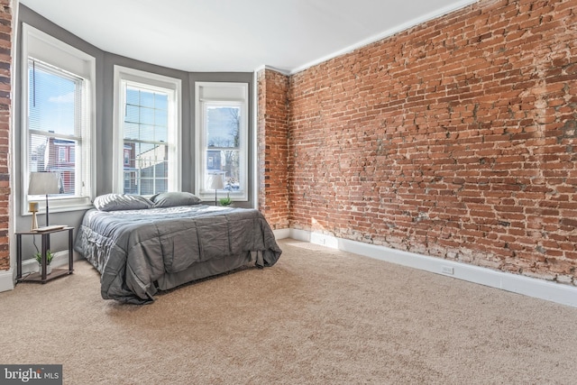 carpeted bedroom featuring brick wall