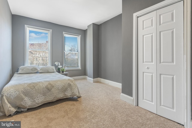 bedroom featuring a closet and light carpet