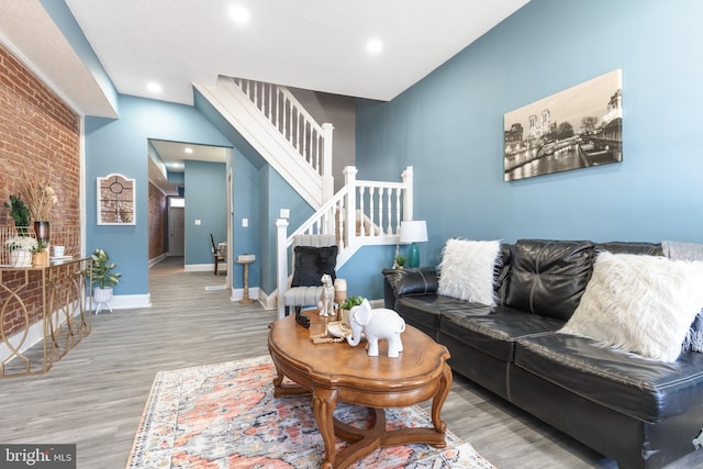 living room featuring brick wall and wood-type flooring