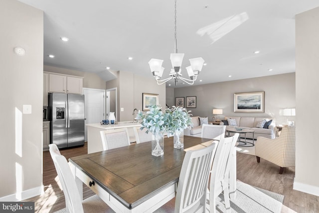 dining area with an inviting chandelier, dark hardwood / wood-style flooring, and sink