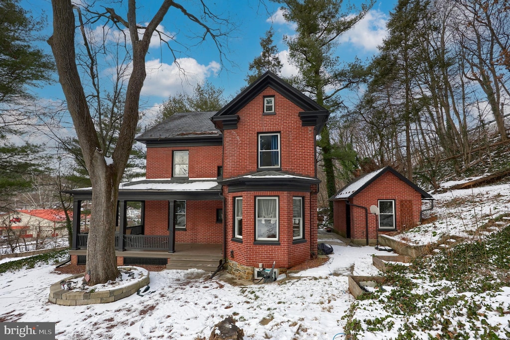 view of front of home featuring a storage shed and a porch