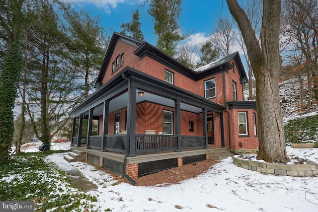 view of snowy exterior featuring a porch