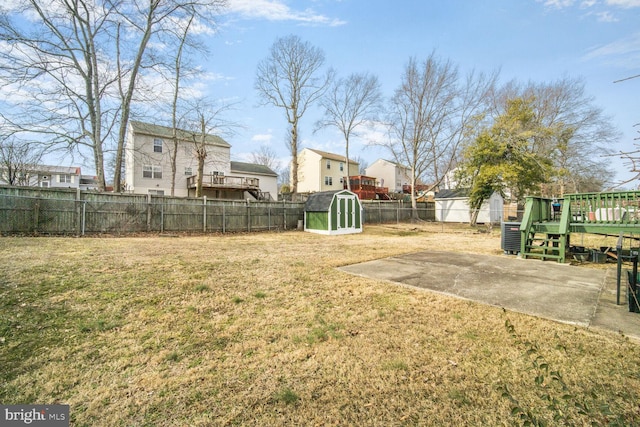 view of yard with a residential view, a fenced backyard, a patio, and a deck