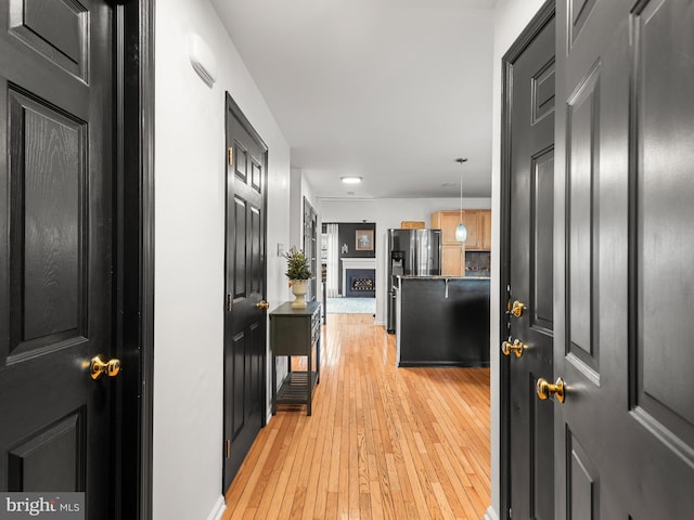 hallway with light hardwood / wood-style floors