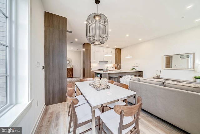 dining room featuring sink and light wood-type flooring