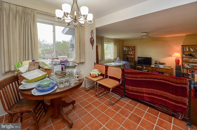 tiled dining room with a healthy amount of sunlight and ceiling fan with notable chandelier