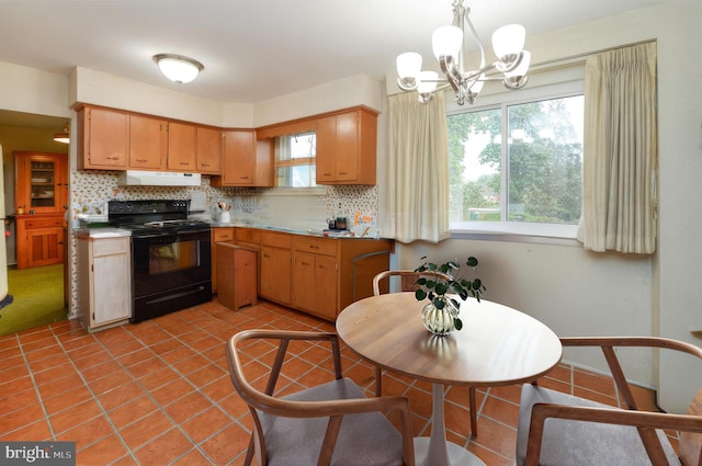 kitchen with tasteful backsplash, a chandelier, black electric range, and pendant lighting