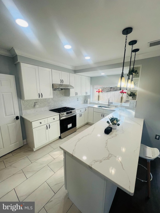 kitchen featuring hanging light fixtures, white cabinetry, kitchen peninsula, and stainless steel gas range oven