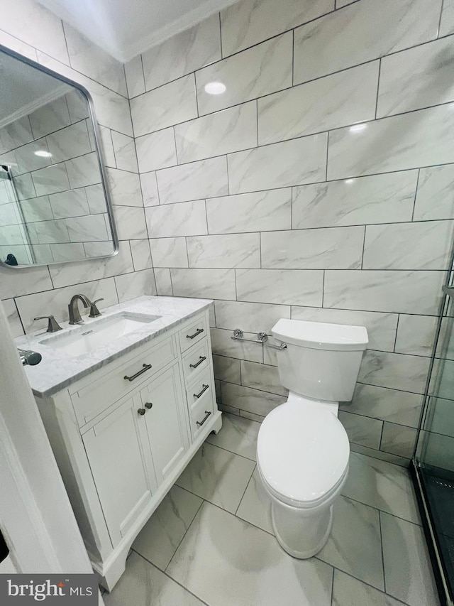 bathroom with tile walls, toilet, crown molding, and vanity