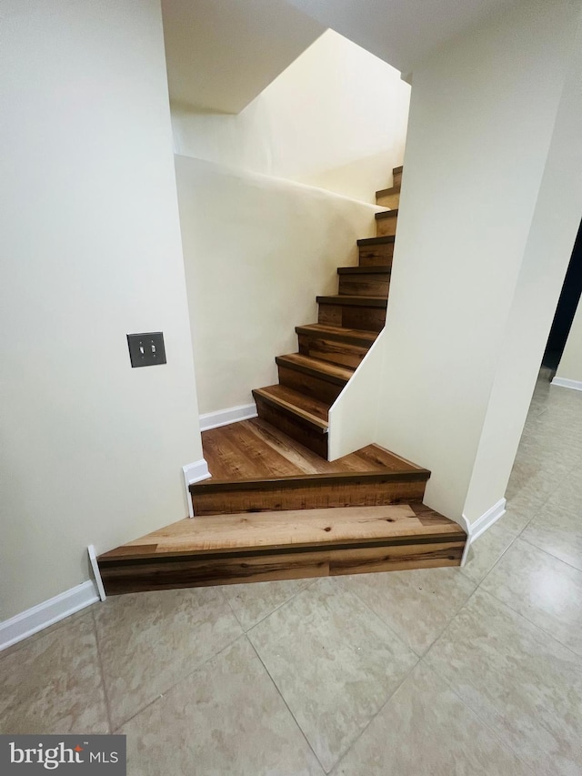 staircase featuring tile patterned flooring