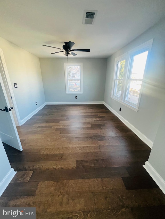 empty room featuring dark hardwood / wood-style flooring and ceiling fan