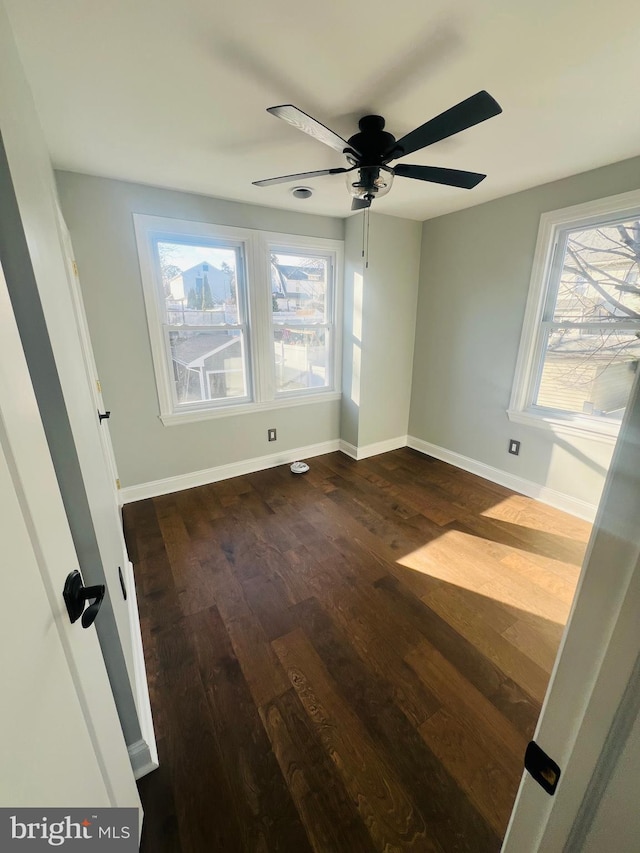 empty room with ceiling fan and dark hardwood / wood-style floors