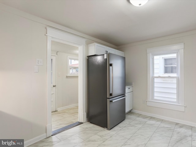 kitchen featuring stainless steel fridge and white cabinets