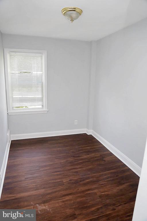 unfurnished room featuring dark wood-type flooring