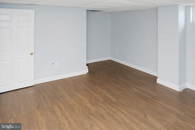 basement with dark hardwood / wood-style floors and a drop ceiling