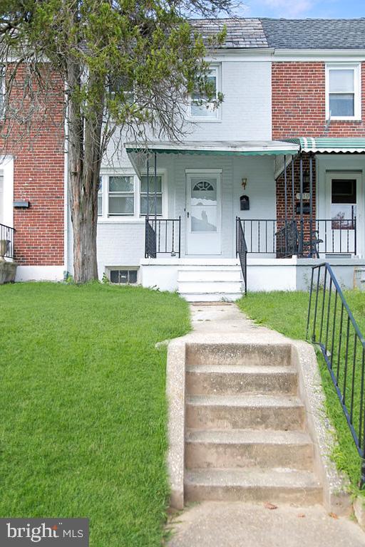 townhome / multi-family property with a porch and a front yard