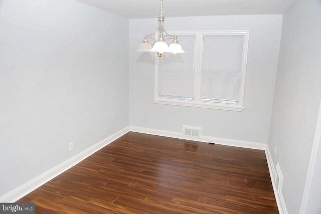 unfurnished dining area with a notable chandelier and dark hardwood / wood-style floors