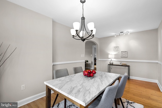 dining area featuring wood-type flooring and a chandelier