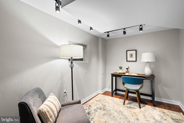 office area featuring rail lighting and dark hardwood / wood-style flooring