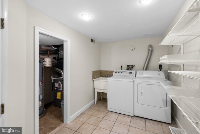 laundry room featuring light tile patterned flooring and washing machine and clothes dryer