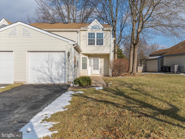 view of front facade featuring central air condition unit, a garage, and a front yard