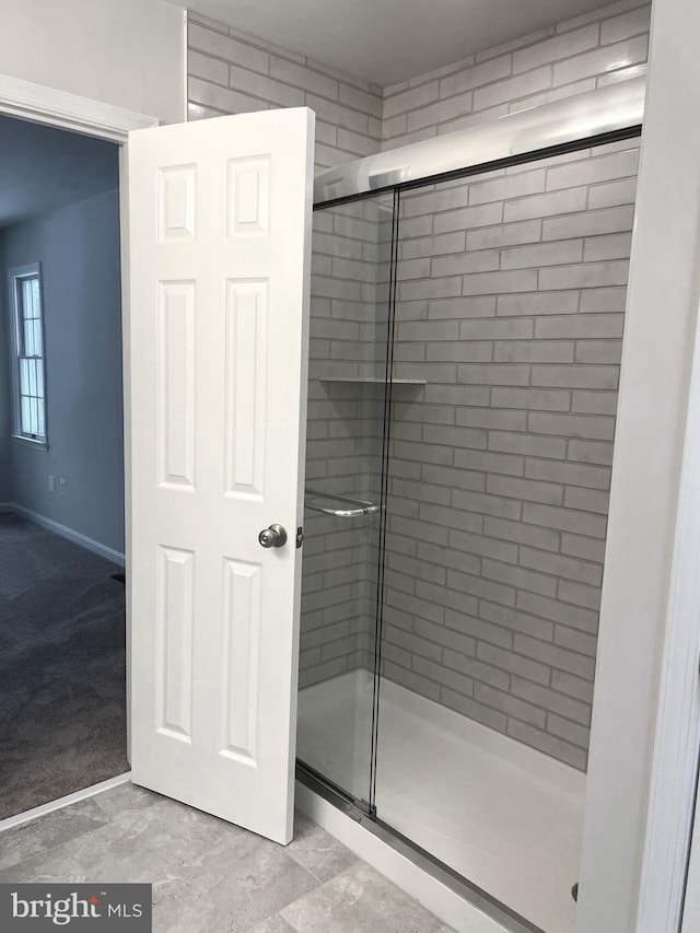 bathroom featuring a shower with shower door