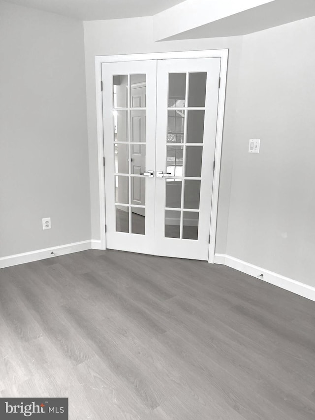 empty room with french doors and hardwood / wood-style floors