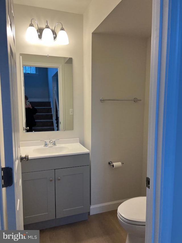 bathroom featuring wood-type flooring, vanity, and toilet