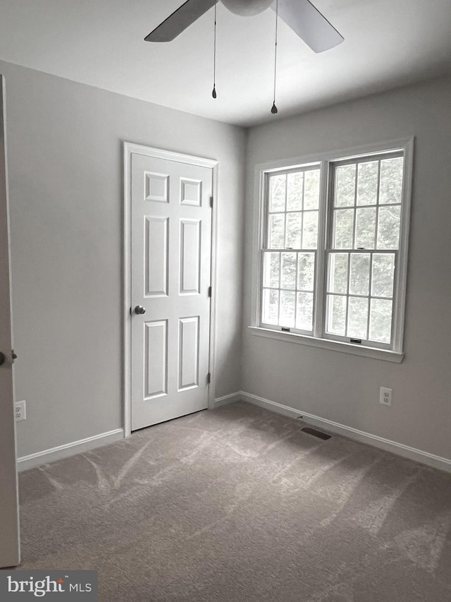 empty room with carpet floors and ceiling fan