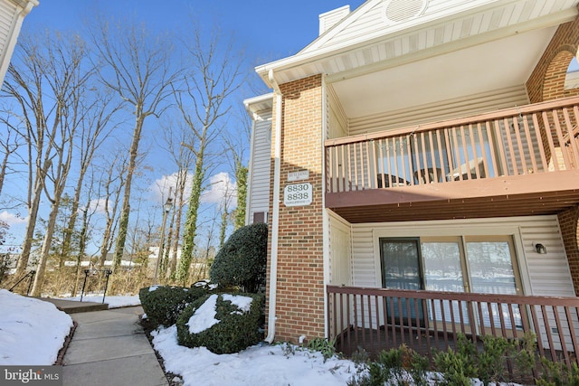 view of snowy exterior featuring a balcony