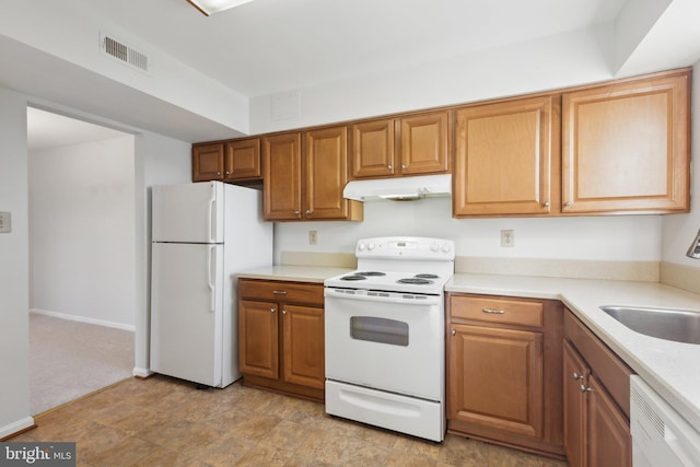 kitchen with sink, light colored carpet, and white appliances