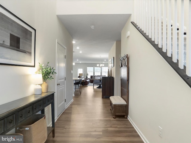 corridor featuring an inviting chandelier and hardwood / wood-style flooring