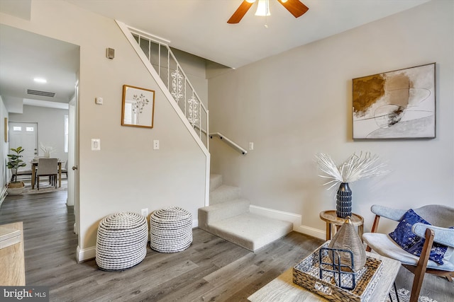 staircase featuring ceiling fan and wood-type flooring