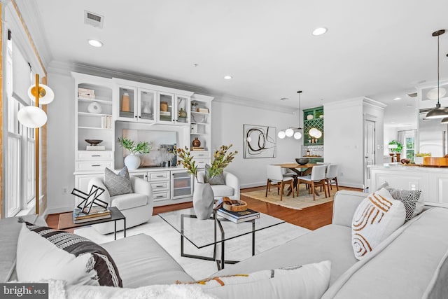 living room with light hardwood / wood-style floors and crown molding