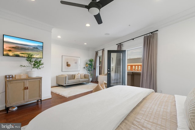 bedroom with ceiling fan, dark hardwood / wood-style flooring, crown molding, and a walk in closet