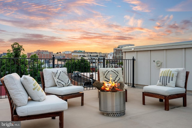 balcony at dusk featuring an outdoor living space with a fire pit