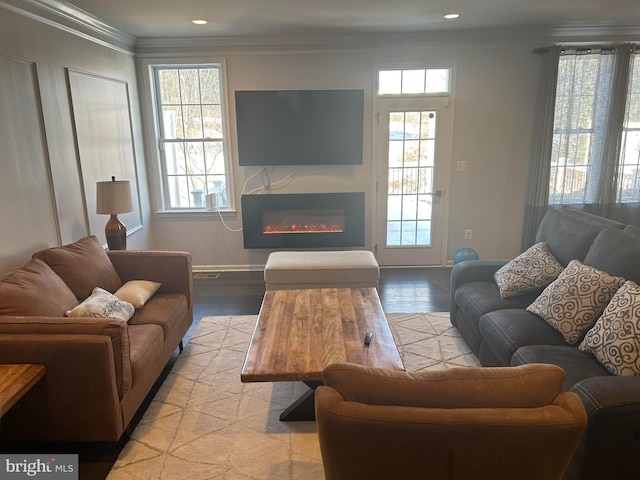 living room with light wood-type flooring, plenty of natural light, and crown molding