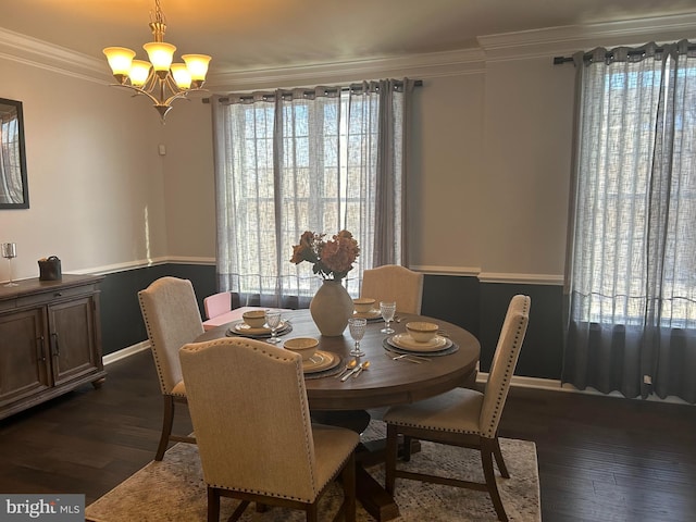 dining space with dark hardwood / wood-style floors, ornamental molding, and a chandelier