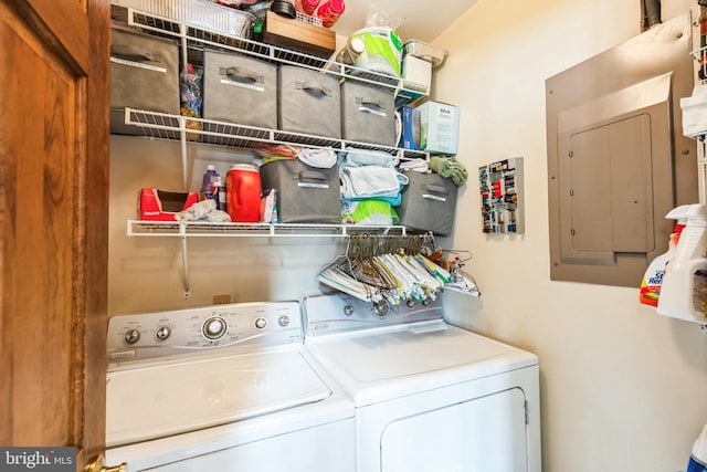 washroom featuring electric panel and washer and clothes dryer