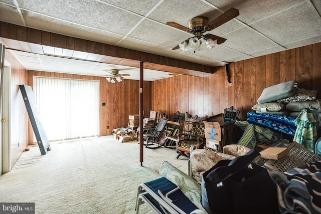 living room featuring wood walls, carpet flooring, and ceiling fan