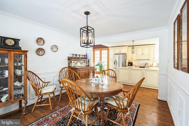 dining area featuring light hardwood / wood-style floors, ornamental molding, and a chandelier