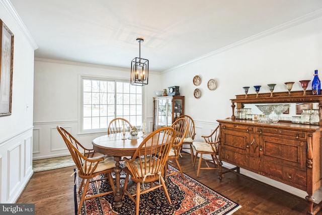 dining room with dark hardwood / wood-style floors, ornamental molding, and a chandelier