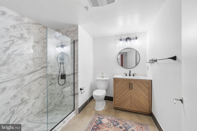 bathroom featuring a tile shower, vanity, and toilet