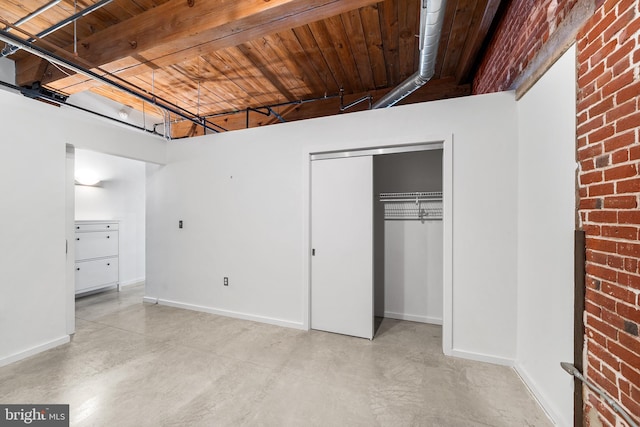 unfurnished bedroom featuring wooden ceiling, a closet, and beam ceiling