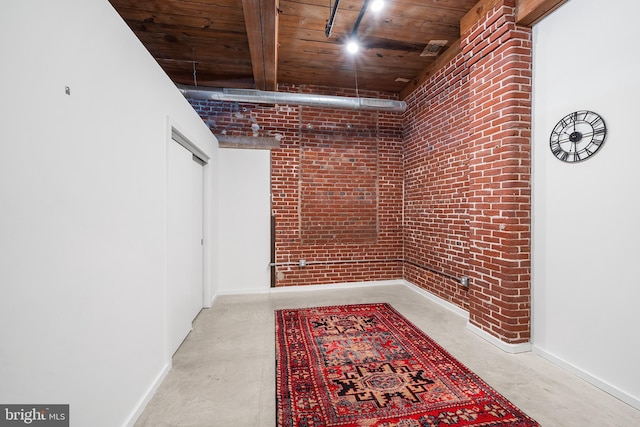 hall featuring wood ceiling and brick wall