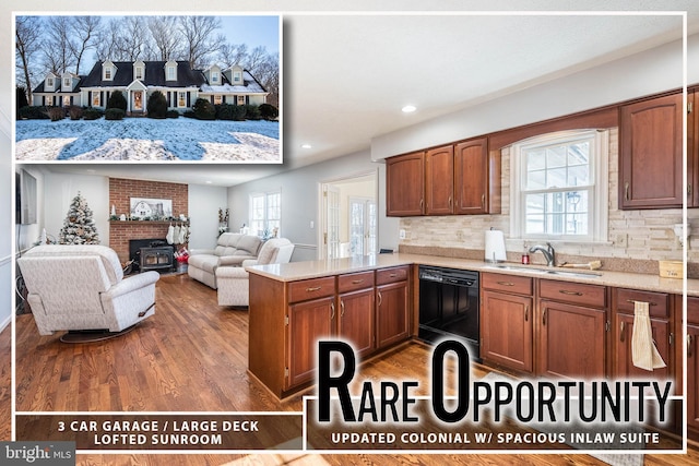 kitchen with hardwood / wood-style floors, black dishwasher, decorative backsplash, sink, and kitchen peninsula