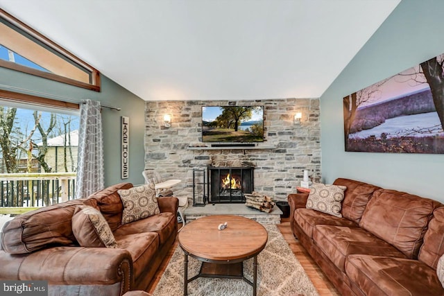 living room with vaulted ceiling and a fireplace