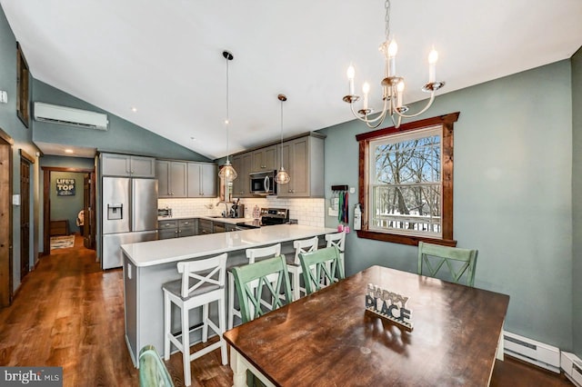 dining room with a baseboard heating unit, dark hardwood / wood-style floors, vaulted ceiling, a notable chandelier, and a wall mounted air conditioner