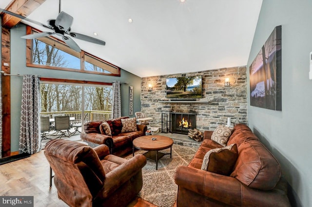 living room featuring hardwood / wood-style flooring, lofted ceiling, ceiling fan, and a fireplace