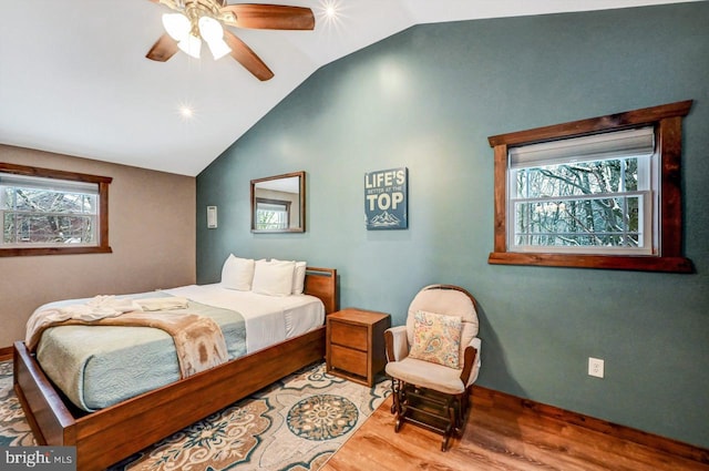 bedroom with ceiling fan, lofted ceiling, multiple windows, and light hardwood / wood-style flooring